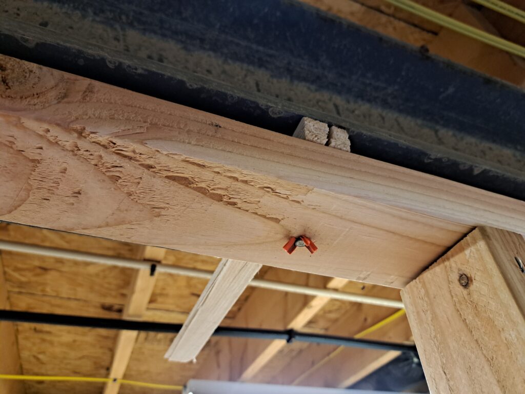 Wall anchored to beam